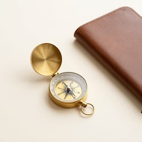 Brass compass beside a leather passport wallet
