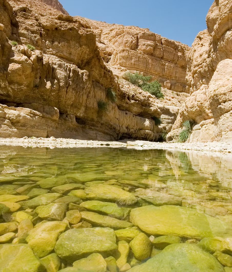 Clear water over smooth stones in a rocky desert oasis